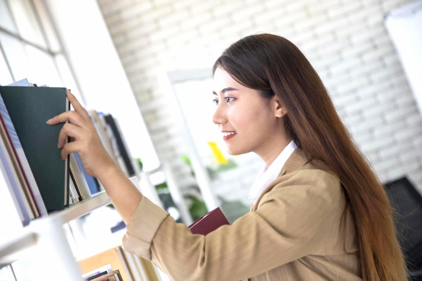 Lernende Person mit Büchern und digitalem Tablet beim Studium